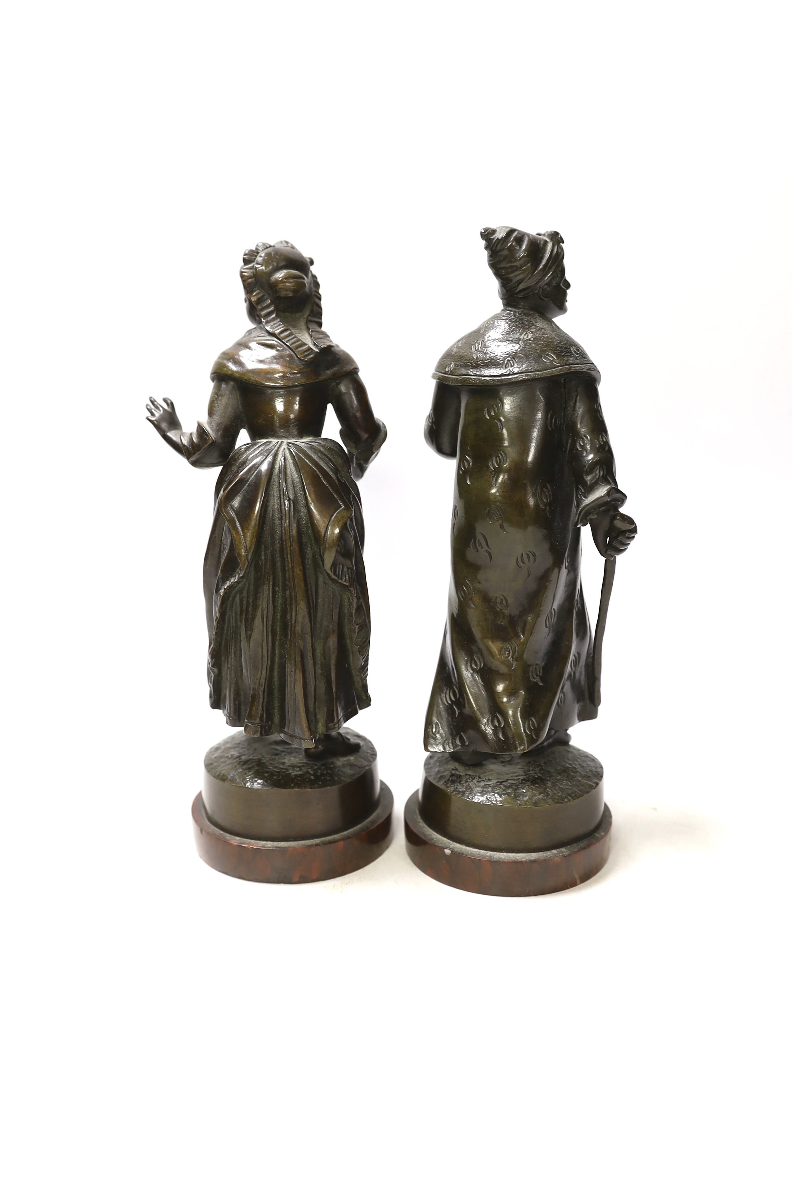 A pair of late 19th century French bronze figures of street sellers, Rouge marble bases, 25cm